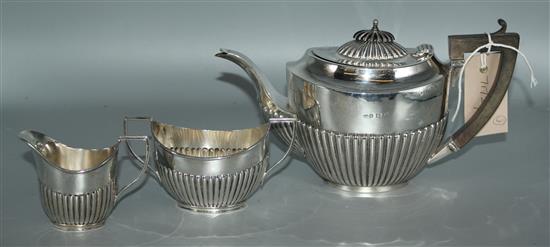 Matched silver three piece tea set of demi fluted oval form
